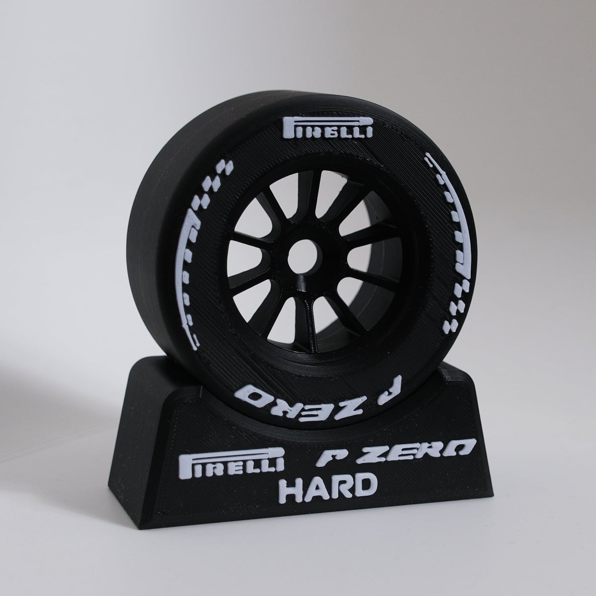 Pirelli P Zero Hard tire model on a stand with a gray background